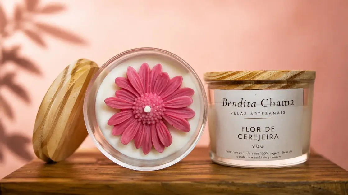 Vela Bendita Chama Flor de Cerejeira de 90 g, com flor de cera rosa moldada sobre a superfície.